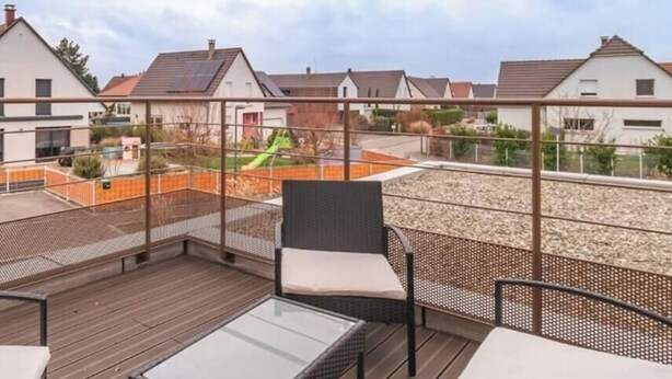 A rooftop terrace with outdoor seating, a view of residential buildings, and a playground in the background. - Charming air-conditioned duplex with terrace - Near the Rhine Ring & Colmar (Niederentzen)