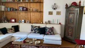 Ein Wohnzimmer mit einer Couch, einem Couchtisch und einem Schrank mit Dekoration.
