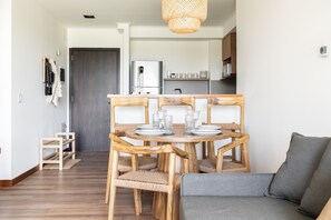 Eine moderne Küche mit Kühlschrank, Esstisch aus Holz und Stühlen.