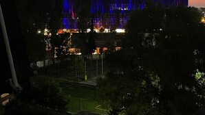 A modern building with a unique facade, surrounded by trees and a clear sky. - Arena Stadium Apartment (Tiranë)
