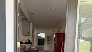 A kitchen with a refrigerator, a dining table, and a rug. - Family Fun Barn - Pet Friendly (Hot Springs)