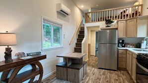 A modern kitchen with a built-in stove, stainless steel appliances, and wooden flooring.