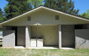 Um pequeno edifício com telhado inclinado, duas portas e uma unidade de ventilação central.