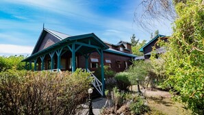 A rustic wooden house with a green roof and a porch. - Hosteria Hainen Cabins, located in El Calafate, 10 minutes from downtown. (El Calafate)