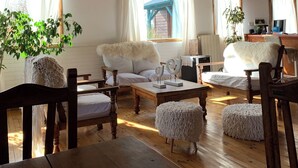 A cozy room with wooden beams, a sofa, a coffee table, and a dining table. - Hosteria Hainen Cabins, located in El Calafate, 10 minutes from downtown. (El Calafate)