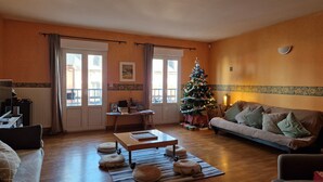 Ein gemütliches Wohnzimmer mit Holzboden, einer Couch, einem Couchtisch und einem Weihnachtsbaum.