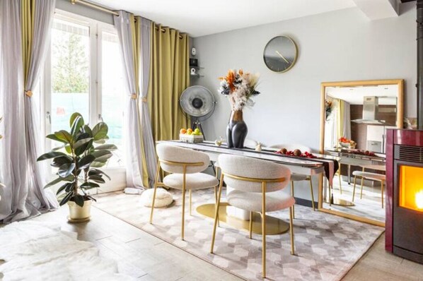 Een moderne keuken met een eethoek, met een groot raam, een potplant en een decoratieve vaas.