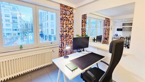 A modern office space with a desk, chair, and large windows offering a city view. - Exceptional 1BR Apartment in center (Luxembourg City)