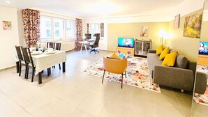 A spacious living area with a dining table, sofa, and TV. - Exceptional 1BR Apartment in center (Luxembourg City)