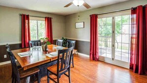 A dining area with a wooden table, chairs, and a ceiling fan. - Enjoyable Home by Airport and Dwtn (Rochester)