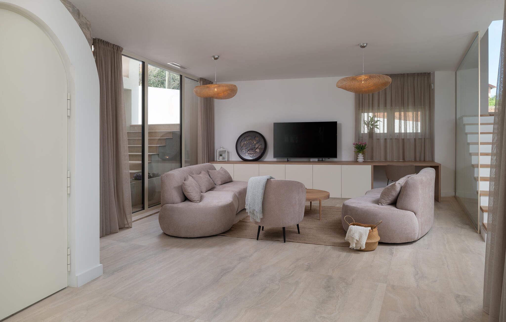 A modern living room with two sofas, a TV, and a large window.