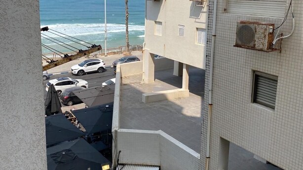 A multi-story building with balconies overlooking a beach. - Charming two-bedroom apartment On The Sea Bat Yam (Bat Yam)