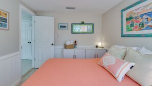 Ein Schlafzimmer mit einem großen Bett, einem Schminktisch, einem Spiegel und einem Bild an der Wand.