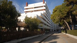 Ein mehrstöckiges Hotel mit moderner Architektur, das Balkone in jeder Etage und einen zentralen Innenhof bietet.