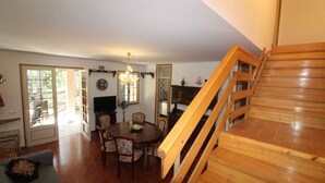 En spiseplads med en trappe i træ, der fører til en etage ovenover.