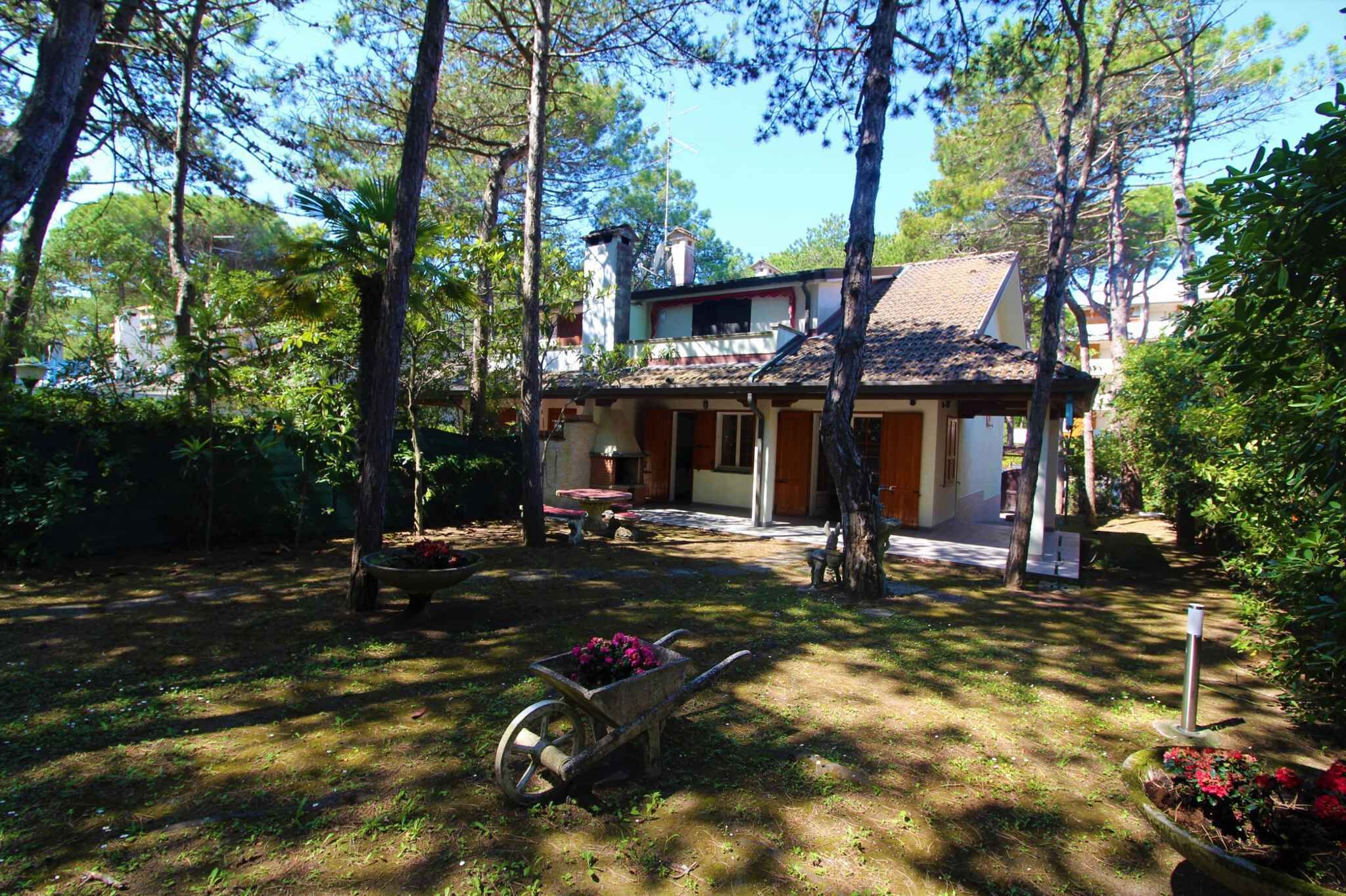 Una casa con techo de tejas, rodeada de árboles y un jardín.