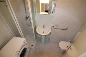 A small bathroom with a sink, toilet, and a washing machine. - Holiday apartment mit Pool (Lignano Sabbiadoro)