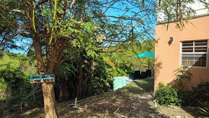 A pathway leading to a building with outdoor seating and a sign indicating a direction to the beach.