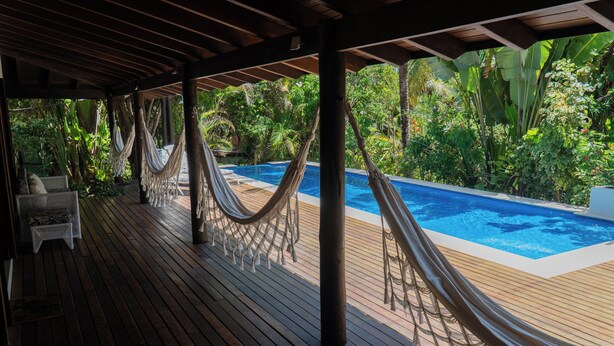A wooden deck with hammocks and a pool. - Luxury Nature Retreat: Hummingbird House (Tibau do Sul)