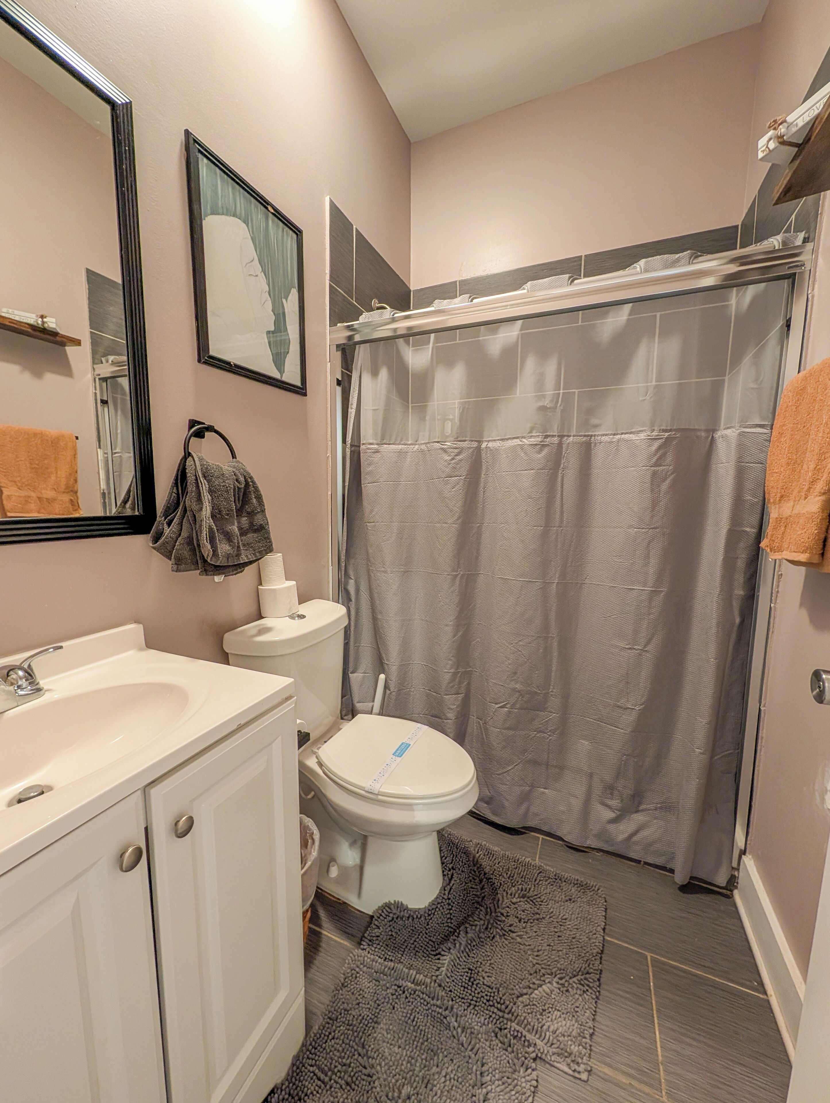 A bathroom with a white sink, toilet, and shower curtain.
