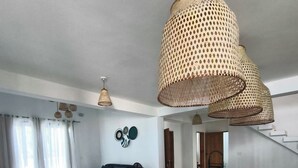 Une cuisine moderne dotée d’un îlot central, de luminaires suspendus et d’un coin repas avec des chaises.