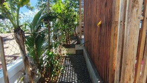 Un sentier bordé de plantes et délimité par une clôture en bois.
