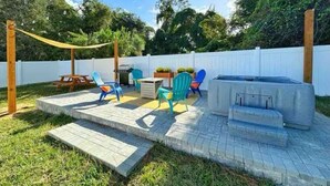A backyard with a patio area, outdoor furniture, and a hot tub. - NEW Gorgeous Sunshine-Up 6 Guests-Private Backyard (Port Orange)