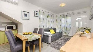 A compact living space with a dining area, a sofa, and a kitchen. - Holiday apartment Apartment A2 (2+2) Ground floor (Srima)