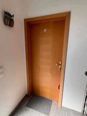 A wooden door with a number '2' sign, a doorknob, and a mat at the entrance. - Holiday Apartment Milenko Ivic 2 (4+0) (Vodice)