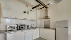 A modern kitchen with white cabinets, stainless steel appliances, and a visible dishwasher.