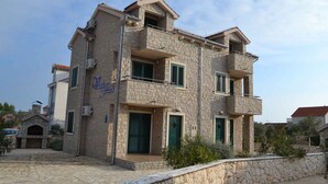 A stone building with multiple balconies and a sign indicating it is a hotel. - Holiday Apartment Trio 12 (2+0) (Srima)