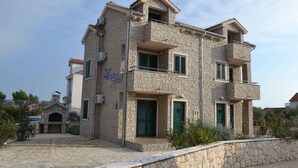 A stone building with a balcony, a small attached structure with a chimney, and a paved driveway. - Holiday Apartment Trio 13 (2+1) (Srima)