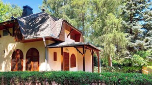 Una casa tradizionale con tetto spiovente, persiane di legno e un portico coperto.