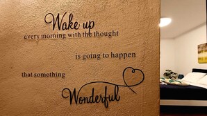 A motivational quote on a textured wall in a room with a bed and a plant. - Romantic Suite con Jacuzzi (Isolabona)