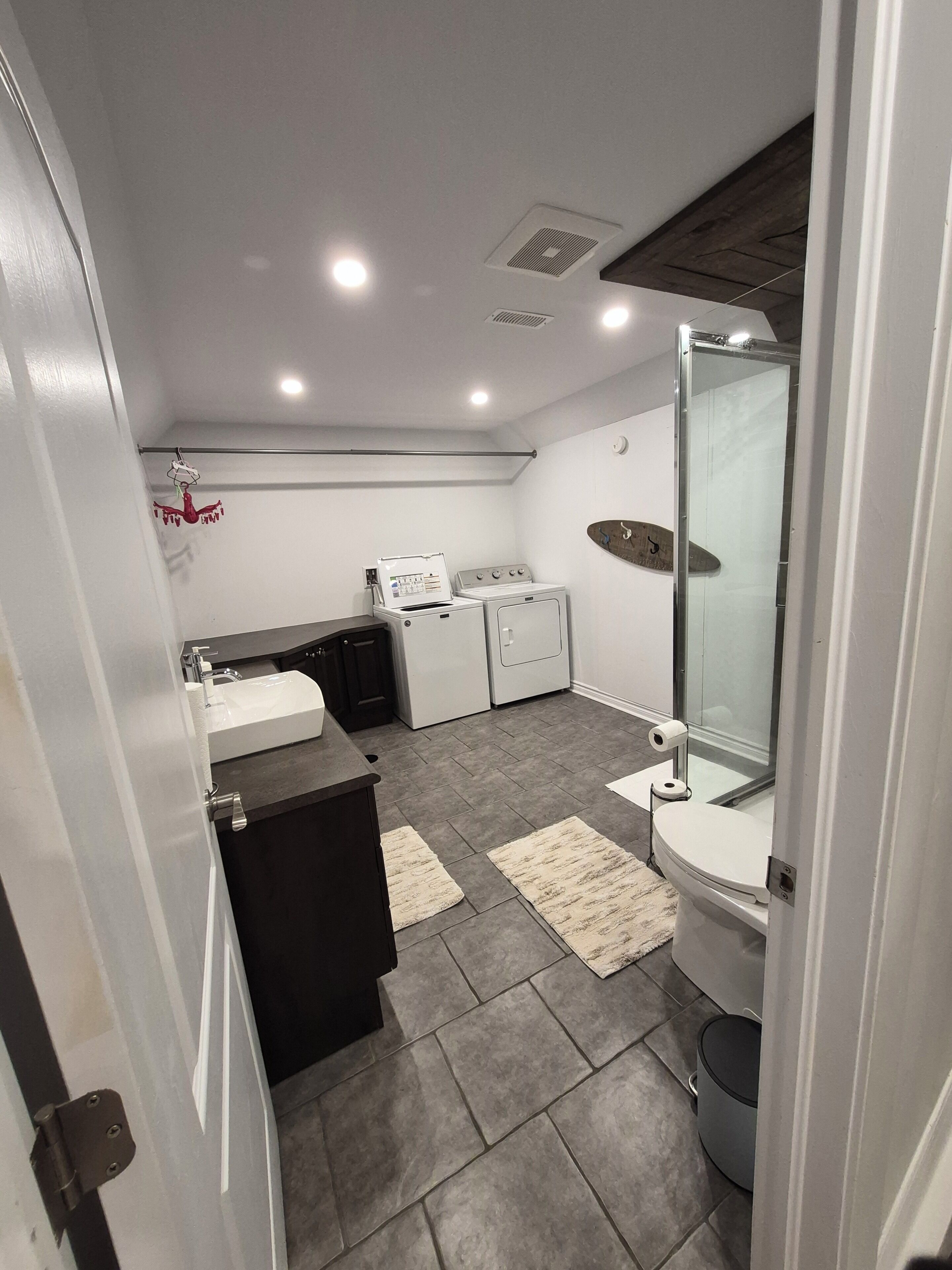 A modern bathroom with a toilet, sink, and shower.