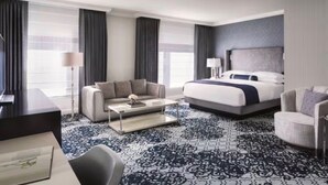 Une chambre d’hôtel avec un lit, un canapé, une table basse et une chaise.
