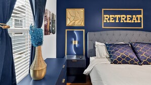 A bedroom with a bed, nightstands, a decorative vase, and a wall with a 'RETREAT' sign. - MusicCityRetreat|3BR2BA|Arcade|Sleep8|EasyDTCommute (Madison)