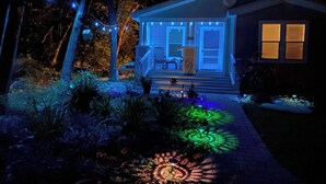 Een huis met veranda, een kleine tuin en lichtslingers.