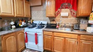 A kitchen with wooden cabinets, a white stove, and various kitchen appliances.