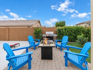 An outdoor patio with a grill, four blue Adirondack chairs, and a brick wall. - Private Pool Oasis Near Spring Training & Luke AFB (Surprise)