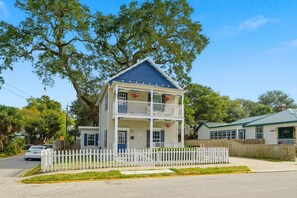 A two-story house with a balcony, a picket fence, and a tree in the background. - Historic Hideaway - Downtown/Night of Lights getaway! (St. Augustine)