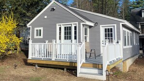 Une maison de plain-pied avec un porche à l’avant, une petite terrasse et un garage.