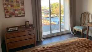 Quarto com cômoda de madeira, uma cadeira e uma cama.