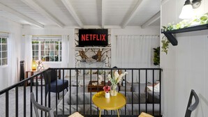 En hyggelig stue med pejs, Netflix-skilt og behagelige siddepladser.