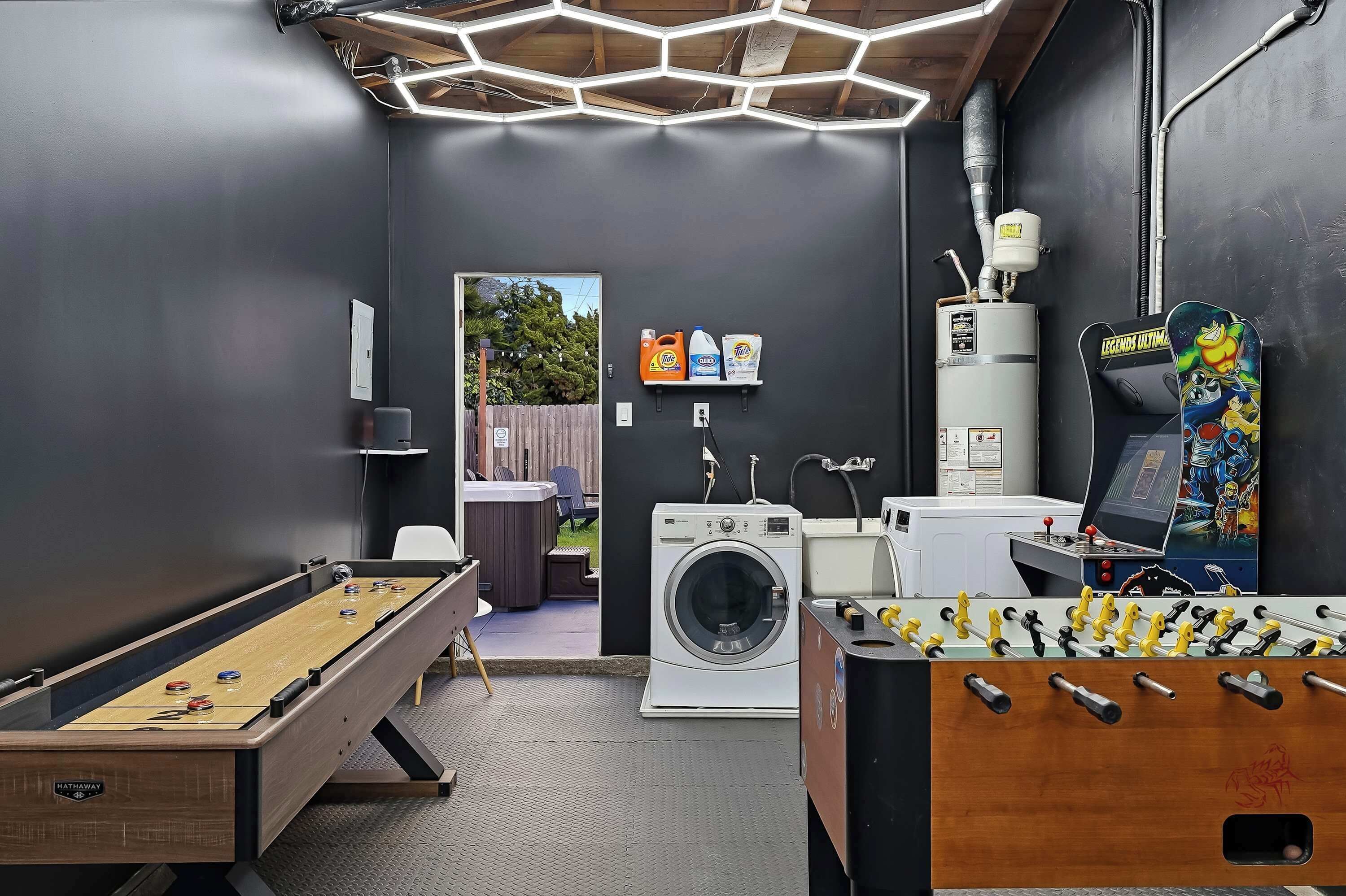 A room with a foosball table, a washing machine, and a heater.