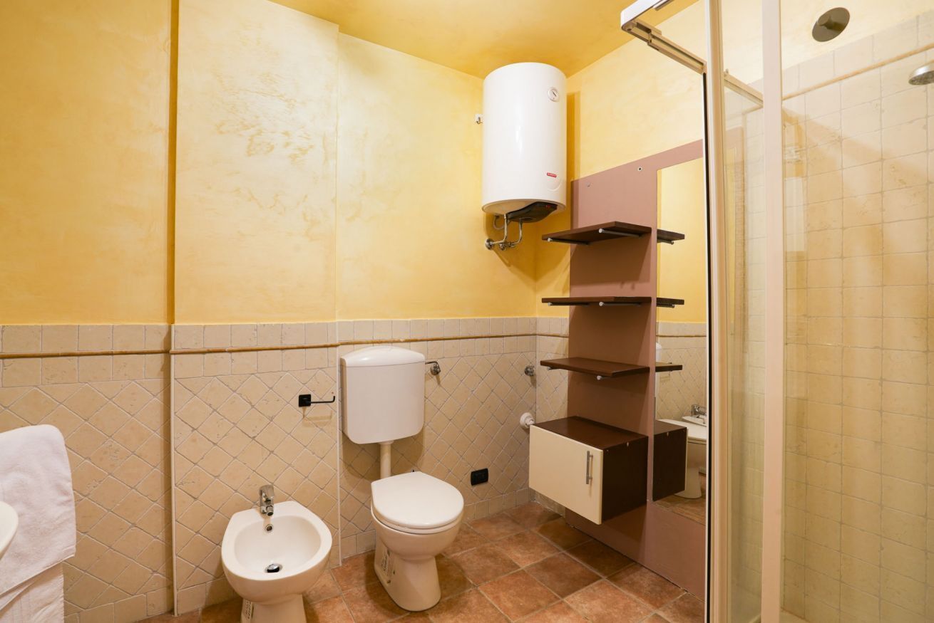 A bathroom with a toilet, bidet, and a shower area.