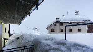 Un espacio exterior cubierto de nieve con una escalera que lleva a un edificio.