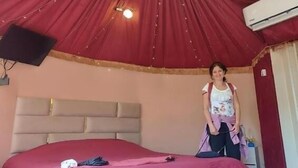 Une chambre à coucher avec un grand lit, une tête de lit, un luminaire au plafond et un appareil de climatisation.