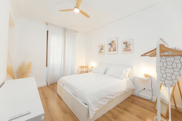 A modern bedroom with a large bed, bedside tables, a desk, and a ceiling fan. - Torino | Belfiore House 59  (Torino)