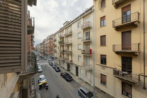 A row of multi-story buildings with balconies, parked cars, and a clear sky. - Torino | Belfiore House 59  (Torino)